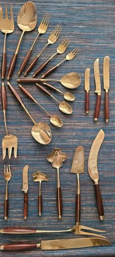 an assortment of gold colored utensils and spoons laid out in a circle