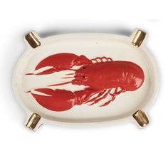 a red and white plate with two lobsters painted on the front, gold trim