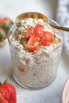 a bowl of oatmeal with strawberries on the side