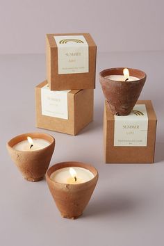 three candles sitting next to each other on top of a table in front of boxes