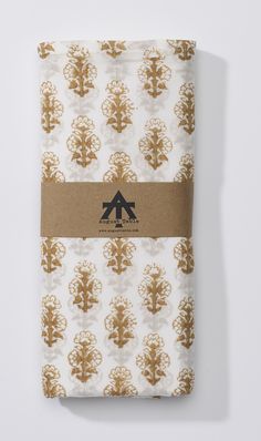 an image of a folded napkin with trees printed on the front and brown stripe down the middle