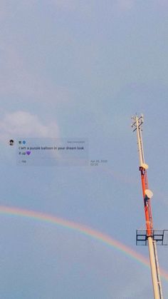 a rainbow appears in the sky above a radio tower