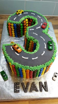 a birthday cake made to look like a number three with cars on it and the letter e