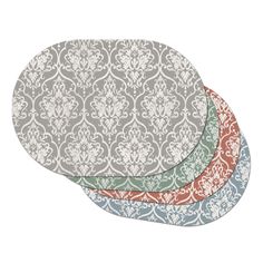 three placemats in different colors and designs, one with an ornate design on it