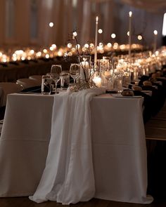 the table is set with candles and wine glasses for an elegant dinner or party event