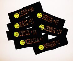 four black stickers with yellow softballs and numbers on them, all labeled in orange