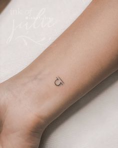 a person's arm with a small tattoo on the left side of their arm