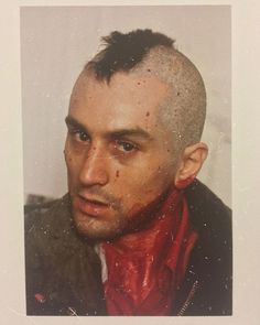 an old photo of a man with a shaved head and red scarves on his face