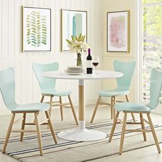 a white table with four chairs and a wine glass on the table in front of it