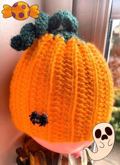 an orange knitted pumpkin sitting on top of a shelf