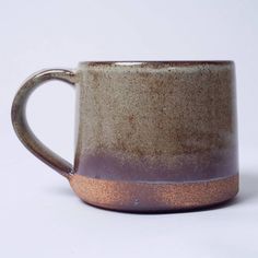 a brown and white coffee cup sitting on top of a table