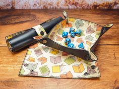 a pair of dice holders on top of a wooden table next to a leather case