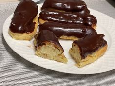 chocolate covered doughnuts are on a white plate