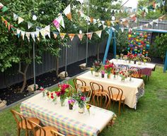 an outdoor dining area with tables and chairs set up in the grass for a party