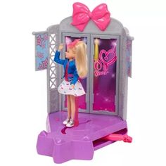 a barbie doll standing in front of a pink and purple toy store with its door open