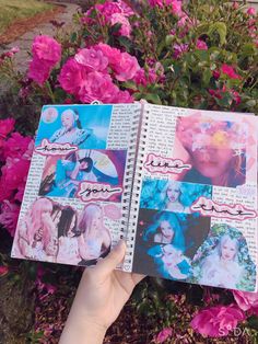 a person holding up a book with pictures on it in front of pink flowers and bushes