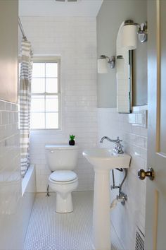 a white toilet sitting next to a sink in a bathroom