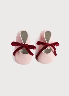 two pairs of pink shoes with red bows on the front and back, one is for toddlers