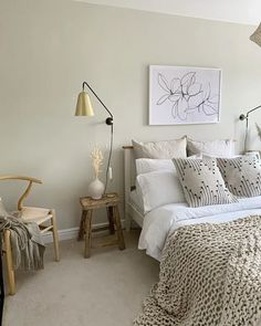 a bedroom with white bedding and animal print comforter on the bed next to a chair