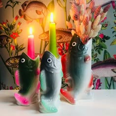 three fish candlesticks sitting next to each other