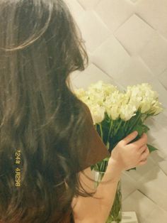 a woman is arranging flowers in a vase