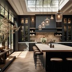 a large kitchen with lots of counter space and lights hanging from it's ceiling