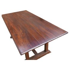 a large wooden table with two legs on each side and one leg raised up to the top