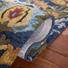 a close up view of a rug on the floor with wood floors in the background