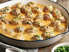 a casserole dish with meatballs and gravy in it on a wooden table