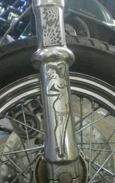 the front wheel of a motorcycle with a drawing on it's spokes and tire