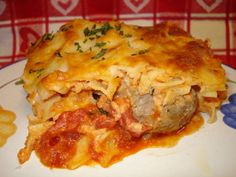 a white plate topped with lasagna covered in meat and cheese