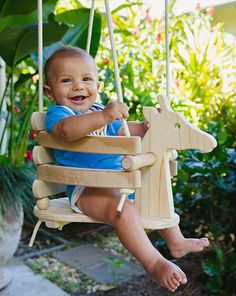 a baby sitting on a wooden rocking horse