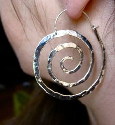 "These swirl hoops are hand pound, shaped and polished. Great for every day. The texture and hand forged quality catches the light and give these simple earrings dimension. Available in solid copper, bronze or sterling silver with hand made ear wires of sterling silver. Large 2 1/8\" H x 1 7/8\" W Ancient spiral meaning: Evolution, Life, Consciousness, Creation Finish: Satin finish is a matte brushed finish. High shine is a brilliant high polish. Each pair is individually shaped, pound and match Spiral Earrings, Spiral Meaning, Everyday Earrings, Sacred Spiral, Simple Earrings, Lily Jewelry, Nautilus, Spiral Jewelry, Diy Jewelry Inspiration