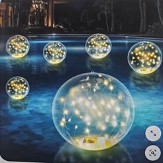 a bunch of lights that are inside of a glass ball on the ground in front of a pool