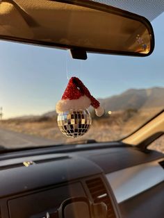 a car dashboard with a mirror ball hanging from it's ceiling and a santa hat on top