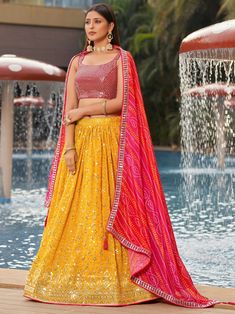 Introducing our gorgeous yellow sequins georgette haldi wear lehenga choli, a stunning ensemble perfect for weddings, ethnic occasions, and special functions. This beautiful set includes a yellow color georgette material lehenga adorned with zari work, sequin work, and thread embroidered work, paired with a pink color georgette material choli featuring similar exquisite detailing. Completing the look is a pink color chinon dupatta with print work and an attractive lace border.
Crafted from high- Yellow And Pink Lehenga, Bridesmaid Indian, Lehenga For Girls, Yellow Dupatta, Lehenga Crop Top, Indian Lehenga Choli, Party Wear Lehenga Choli, Reception Gown, Party Wear Gown