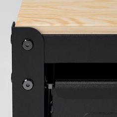 a close up view of the bottom section of a black and wood desk