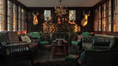 a living room filled with lots of furniture and large windowed in windows next to a fire place