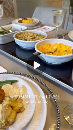 a table topped with plates and bowls filled with different types of food next to wine glasses