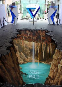 an artistic painting on the ground in front of a waterfall and blue water with icicles hanging from it