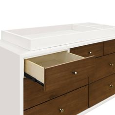 a white and brown dresser with drawers on it's sides, showing the bottom drawer