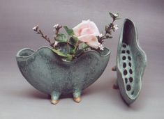 two ceramic vases with flowers in them on a table