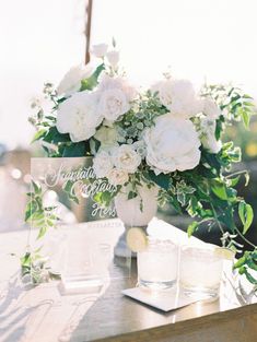 a vase with white flowers sitting on top of a table