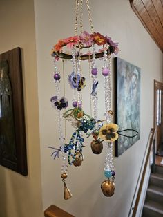 a wind chime hanging from the side of a wall next to a stair case