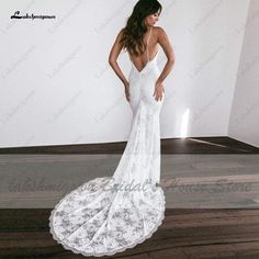 a woman in a white dress standing on a wooden floor with her back to the camera