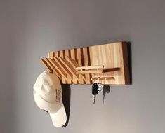 a hat rack with two hats hanging from it's sides and a pair of keys attached to the hooks