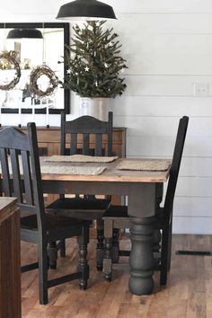 a dining room table and chairs with a christmas tree in the corner on top of it