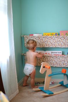 a baby in diapers playing with a rocking horse