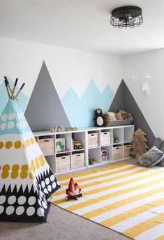 a child's room with a teepee tent and toy storage bins on the floor