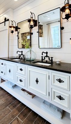 a bathroom with double sinks and mirrors on the wall above them is decorated in black and white